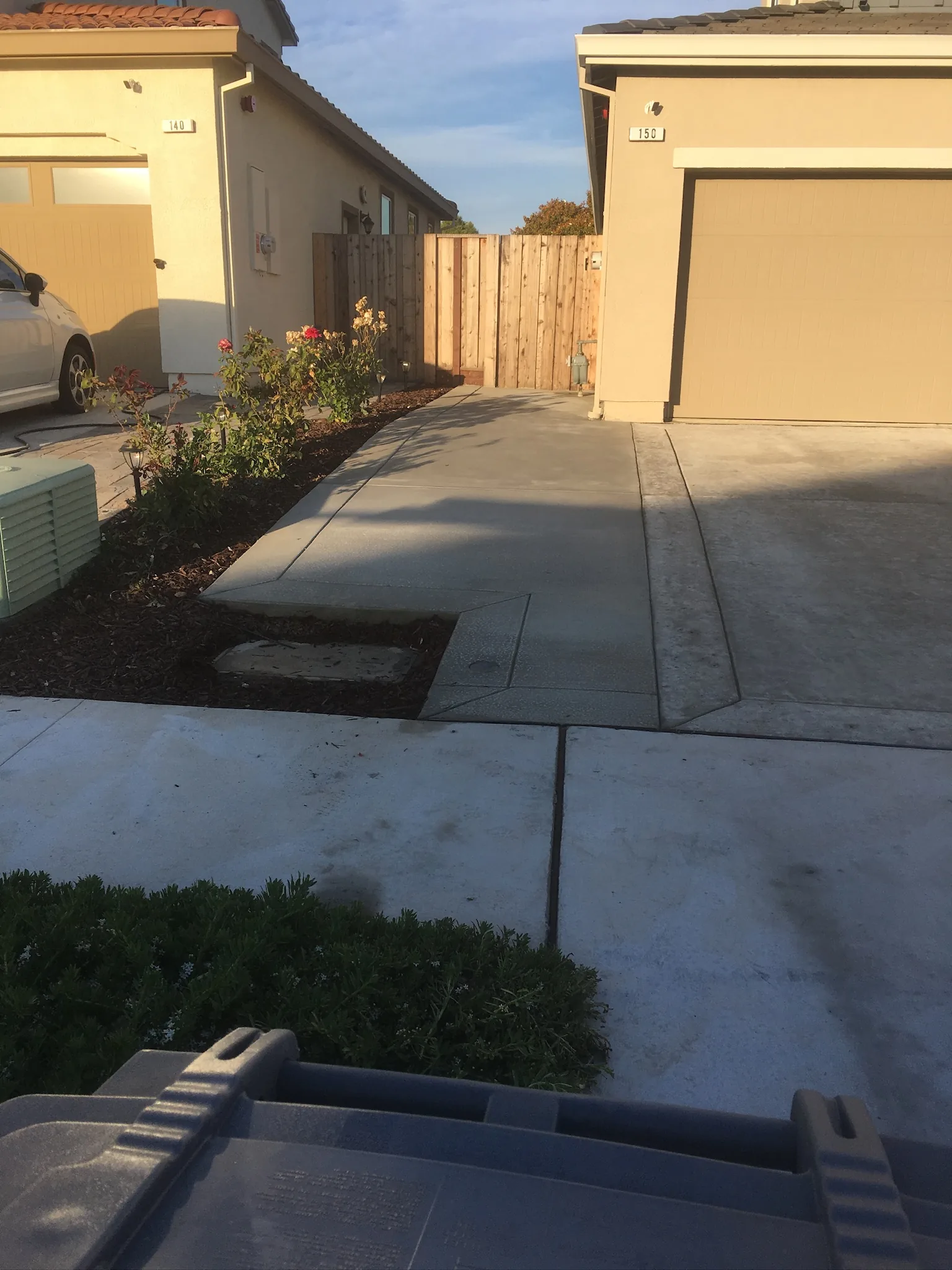 Finished patio slab and low concrete walls beside a modern building