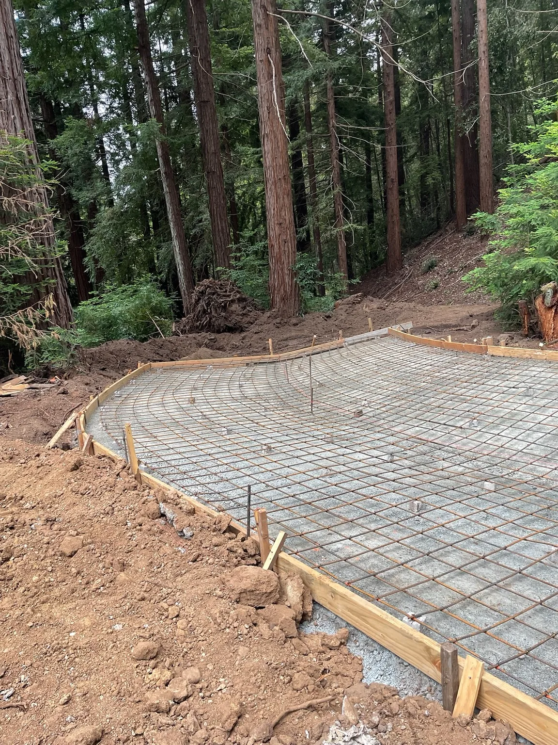 Concrete retaining wall base below a wood fence